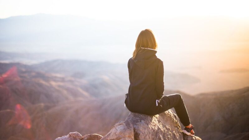 山の頂上に座っている女性